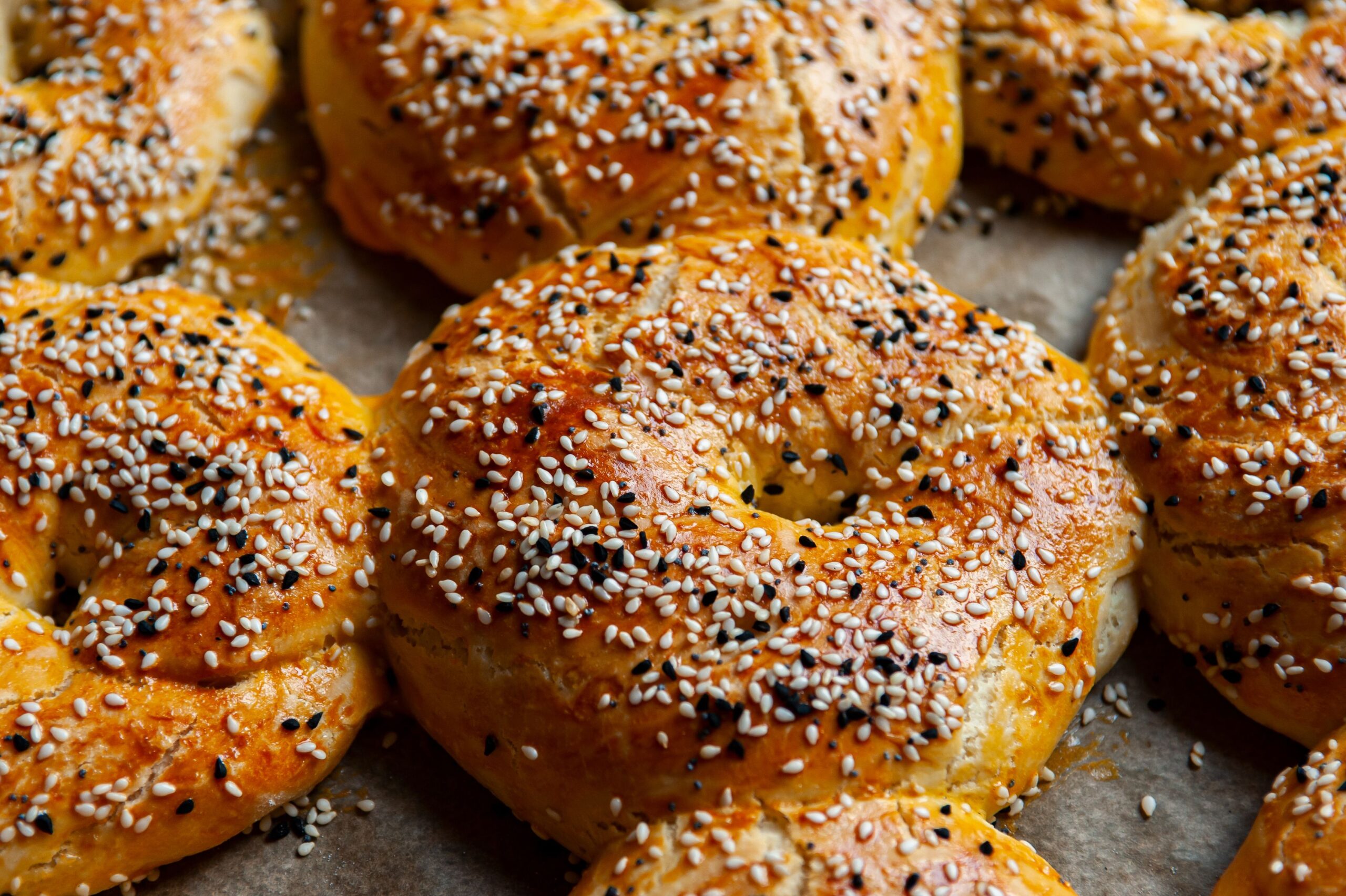 Golden brown bagels topped with sesame seeds straight from the oven.